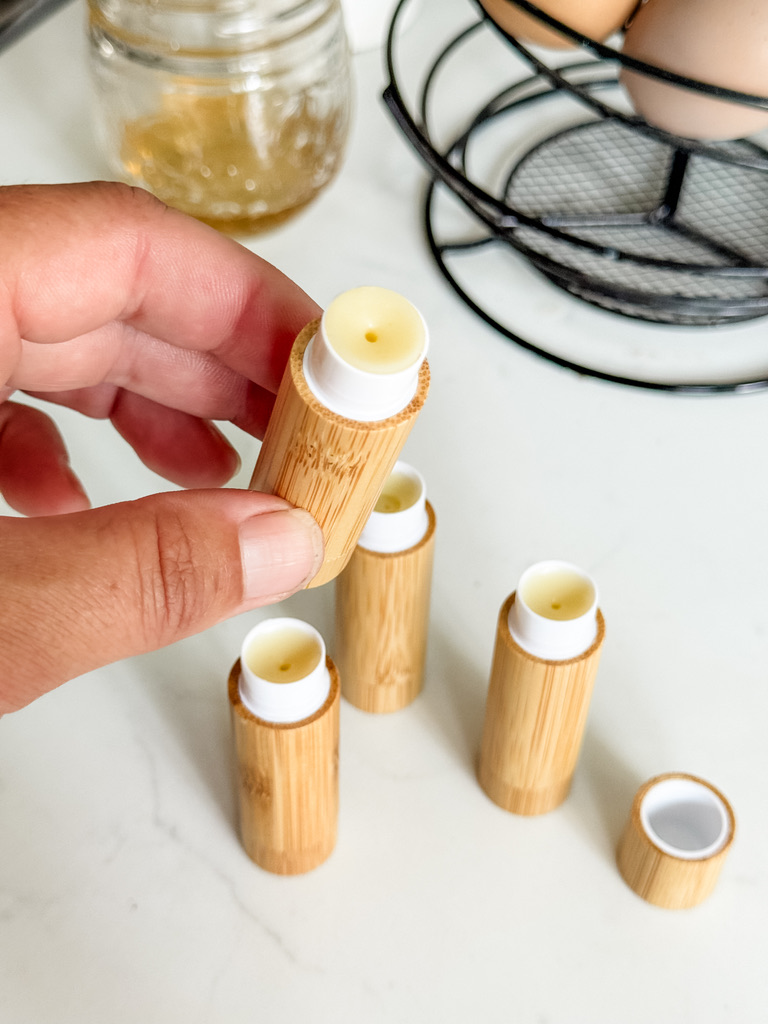 Pouring melted calendula beeswax lip balm into chapstick tubes